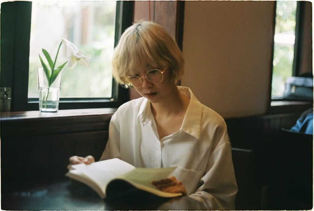 Femme lisant un livre ouvert, image illustrant l’apprentissage du français